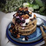 Banana blueberry buckwheat pancakes with blueberry compote, coconut yogurt and toasted walnuts