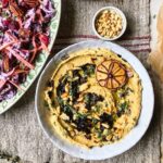 Festive olive dough ball wreath bread with caramelised onion and roast garlic hummus and slaw
