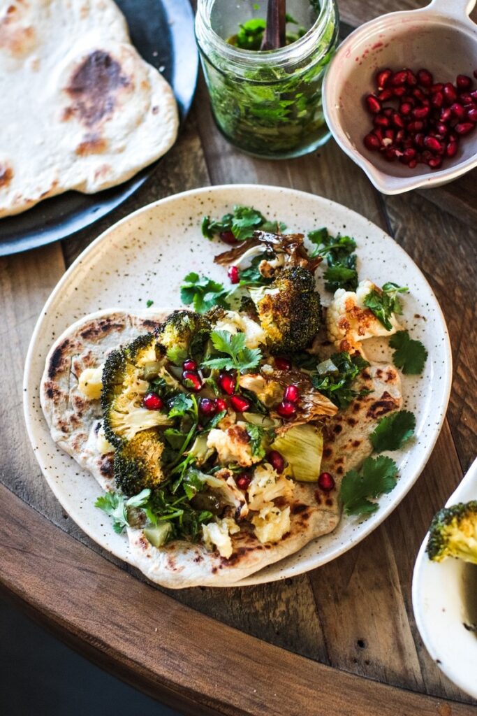 Roast cauliflower & broccoli with crushed celeriac, aubergine dip, herby caper dressing & flatbread