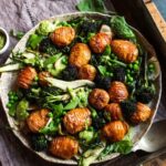 Spring salad with new potato hasselbacks and charred purple sprouting broccoli, fennel & pesto