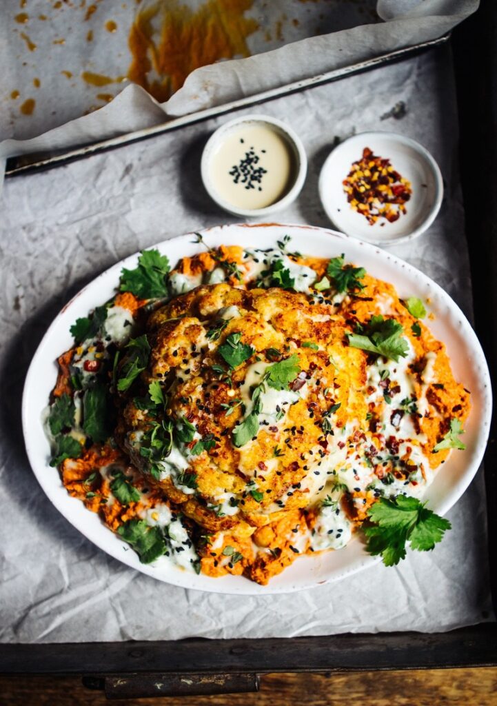 Whole roast cauliflower with smoky tomato sauce, chickpeas and cucumber mint dressing